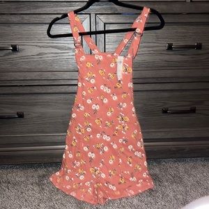 Hollister Romper with flowers. Has two pockets and buttons on sides